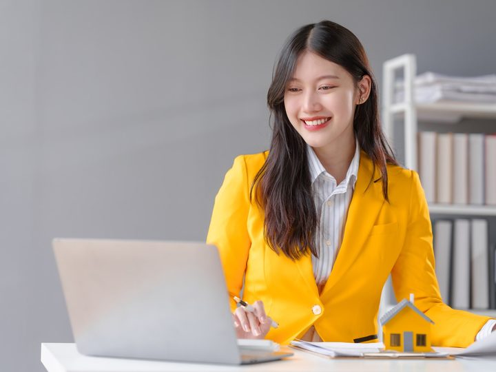 분양 상담 예시 — 주택 모형을 두고 노트북을 보는 상담 직원