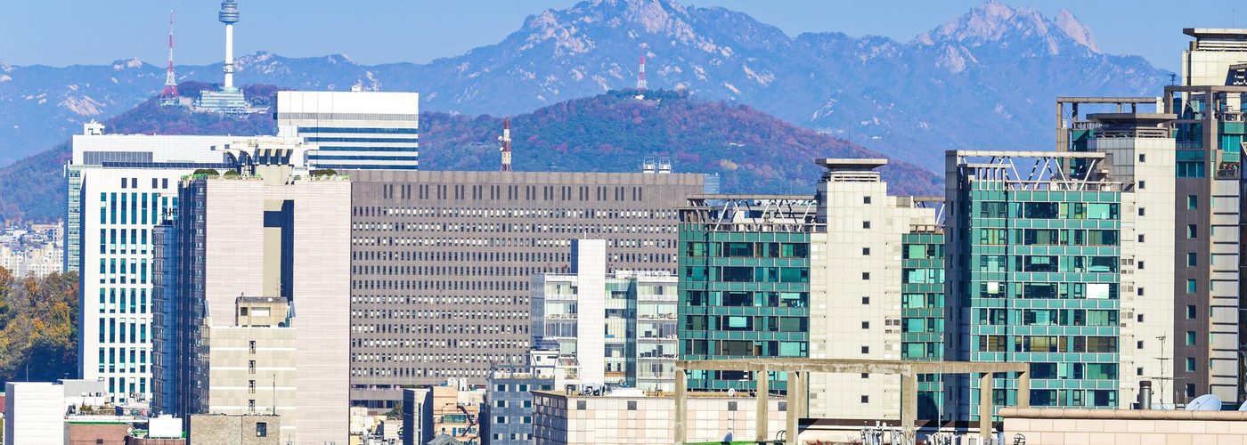 도시 전경 예시 — 가을빛 산과 도심 건물이 겹친 풍경