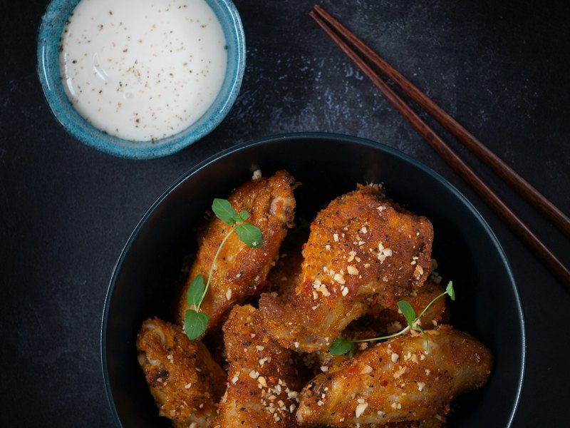 검은 그릇에 담긴 치즈 파우더를 뿌린 치킨