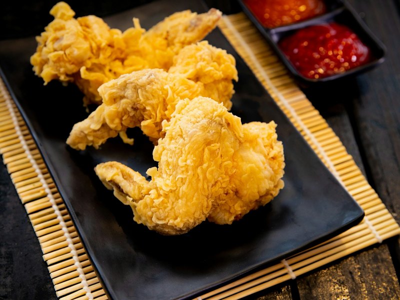 뼈 없는 순살 치킨이 검은 접시에 담긴 모습