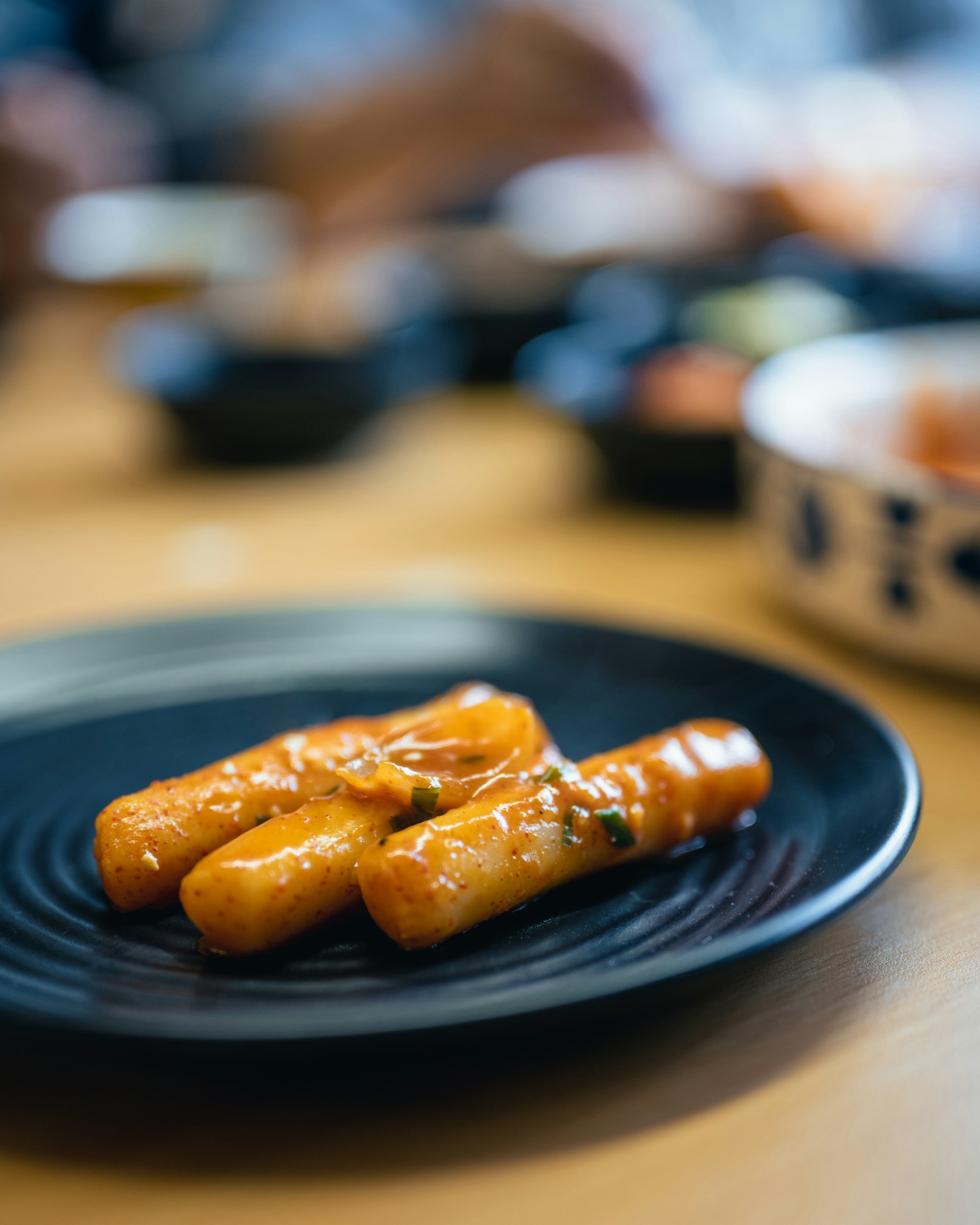 검은 접시에 담긴 치즈 소스 떡볶이