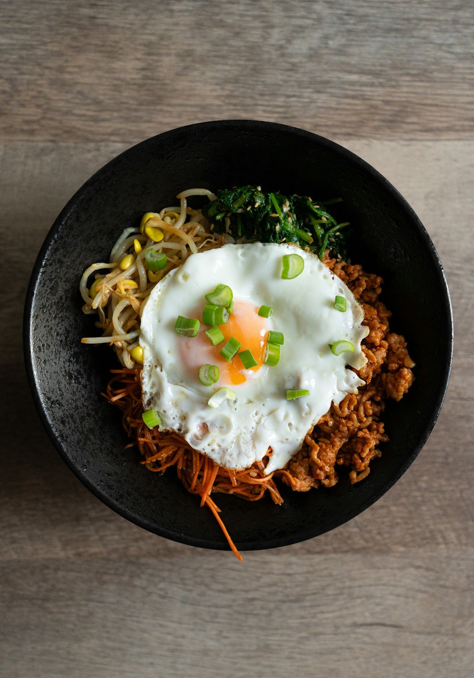 검은 그릇에 담긴 덮밥과 반숙 달걀