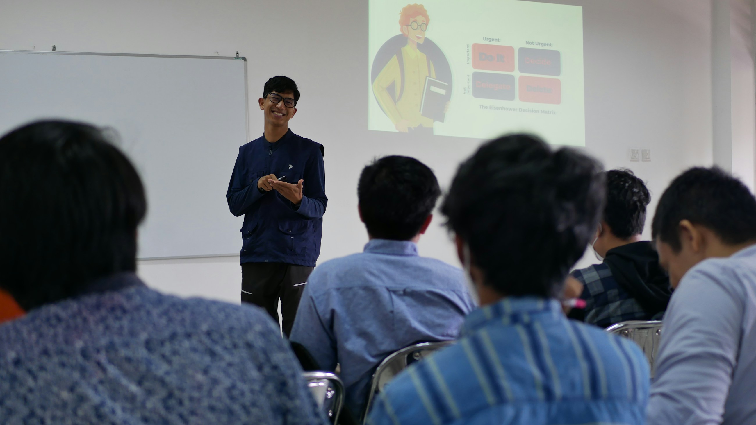 강의실에서 발표자가 화면 자료를 놓고 설명하는 장면