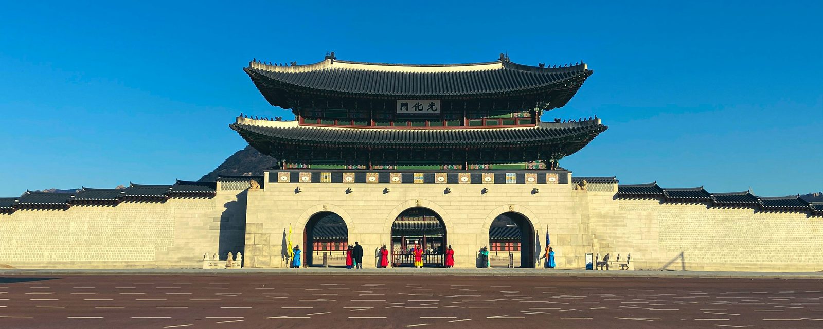 처마가 겹쳐진 목조 문루와 그 앞의 돌계단