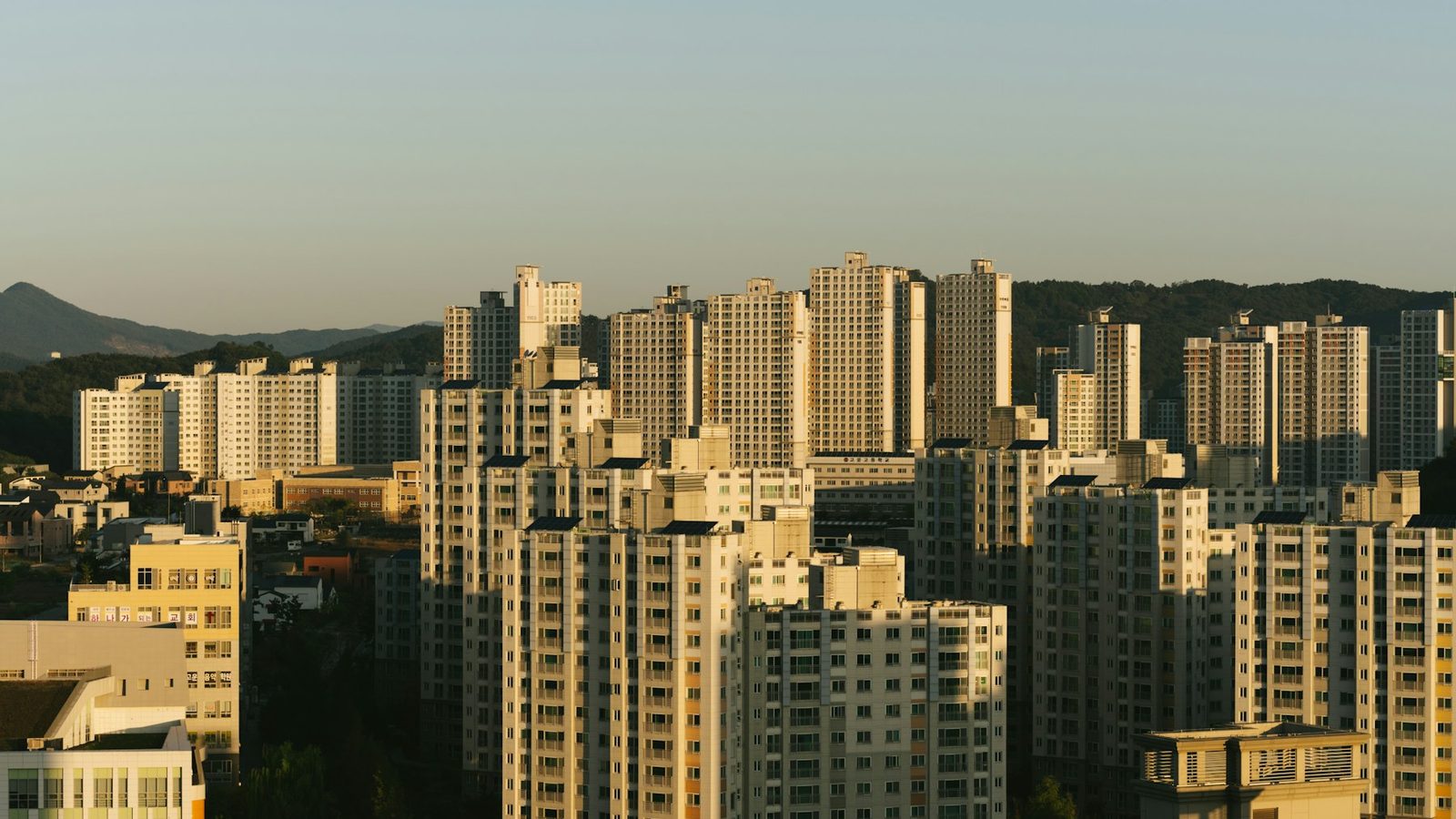 저층 주택가 너머로 아파트 단지가 늘어선 도시 주거지 전경